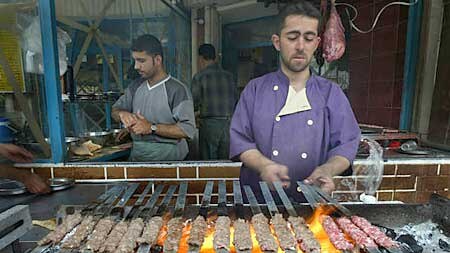 An Iraqi street vendor prepares kebabs in Baghdad