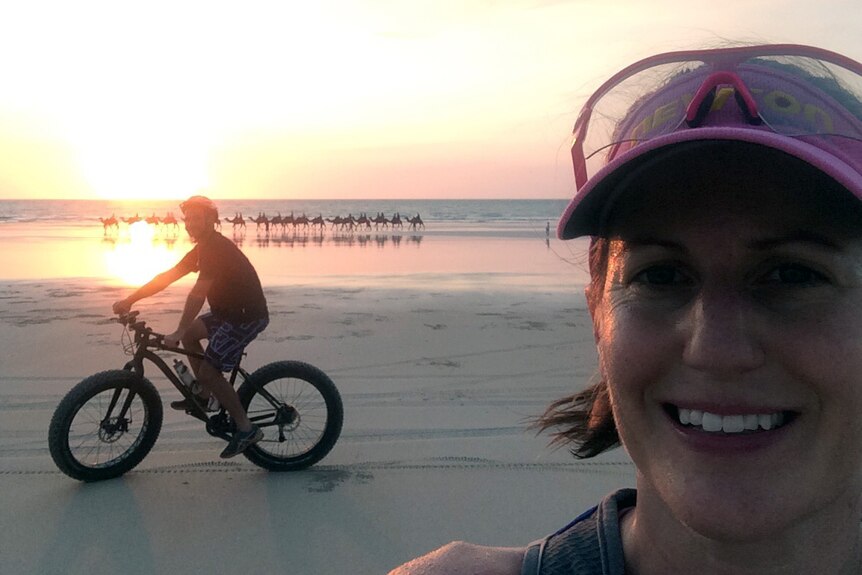 Nicole Smyth with a fellow Kimberley Fat bike Club rider in front of camels on Cable Beach.