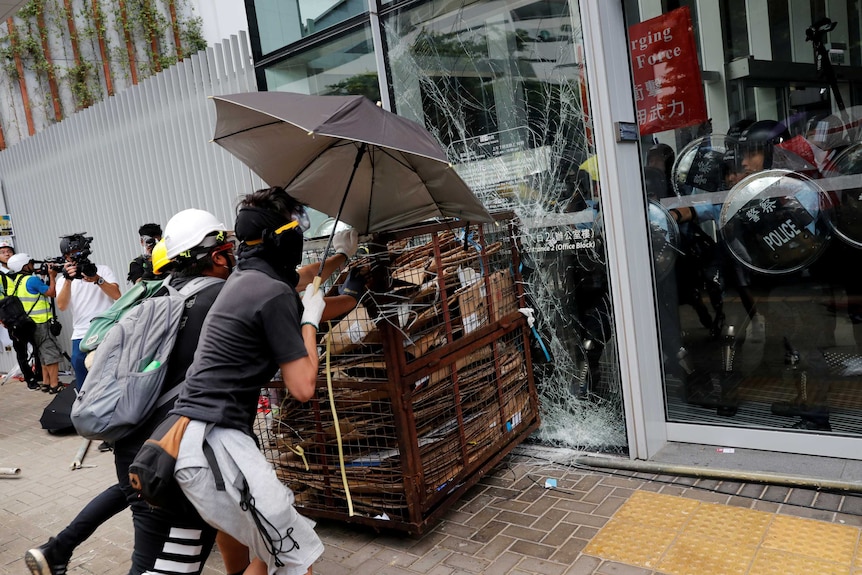 Protesters try to break into the Legislative Council building where riot police are seen