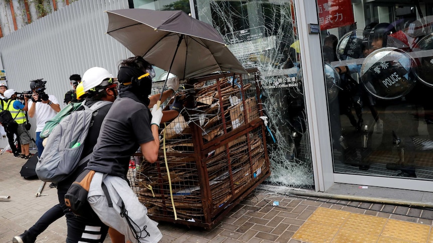 Protesters try to break into the Legislative Council building where riot police are seen