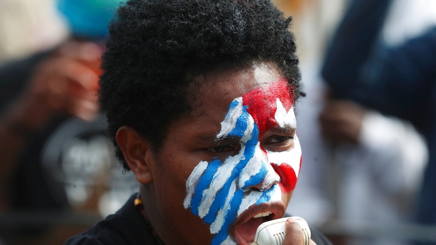A supporter of the independence of the West Papua with face painted with the colors, white, red and blue.
