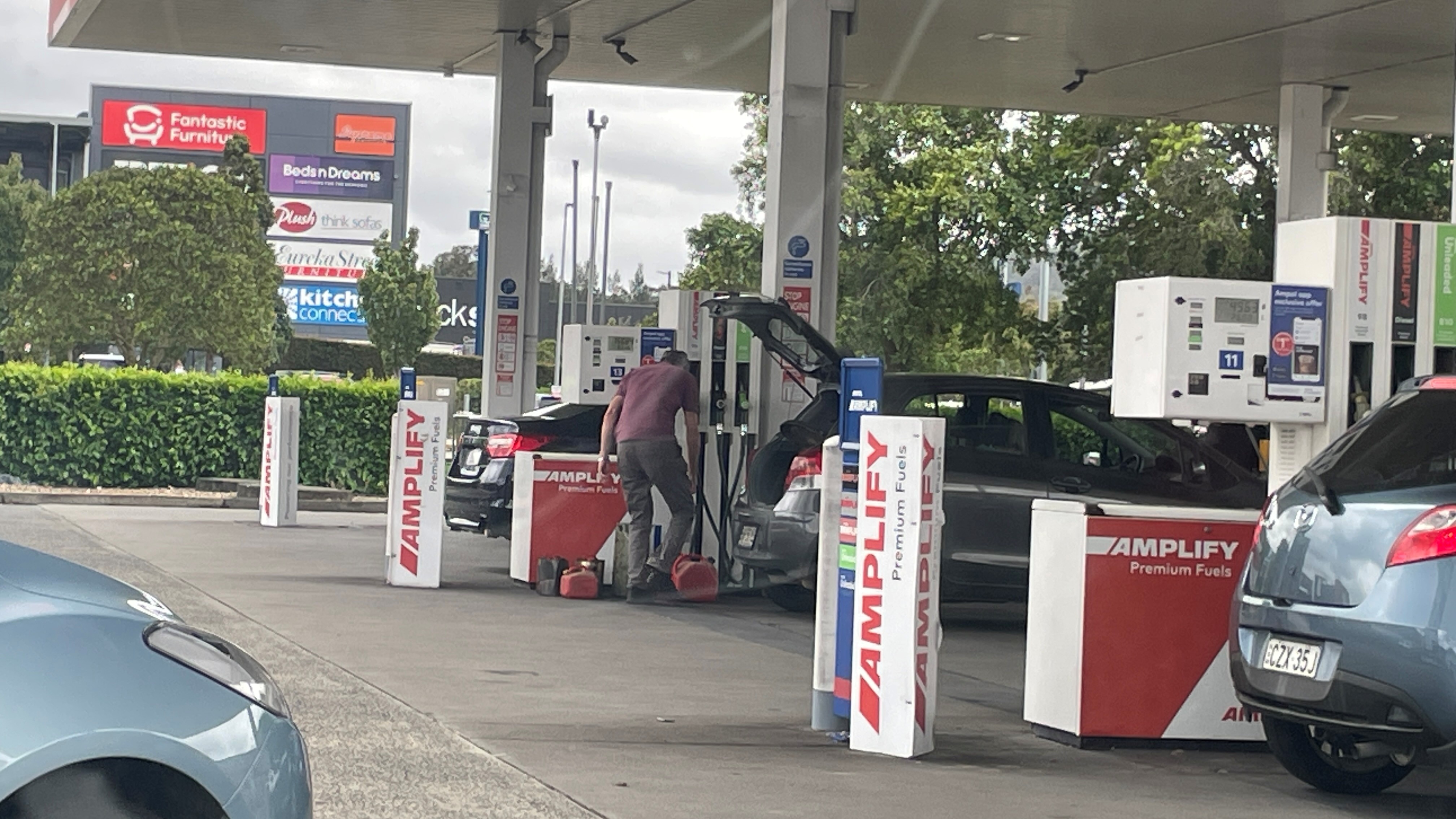 A man fills jerry cans with petrol 