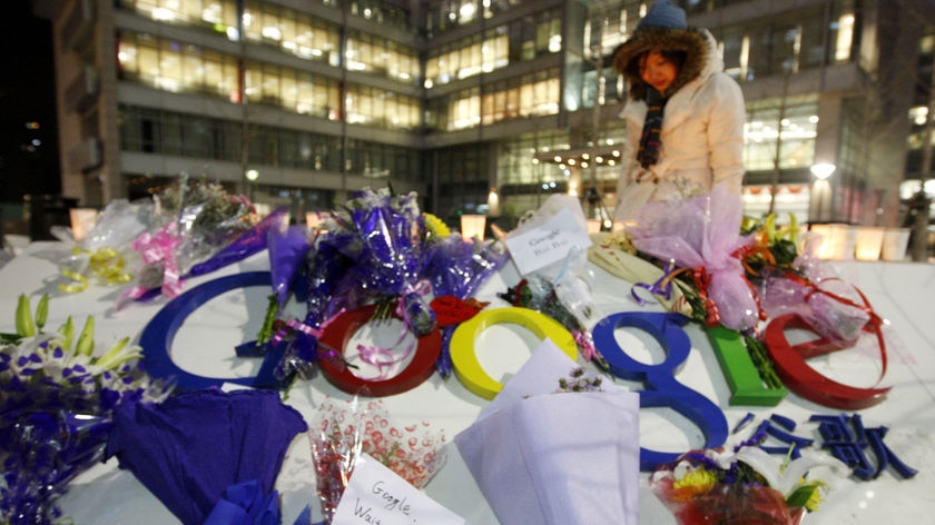 A woman walks by a sign outside the Google China headquarters