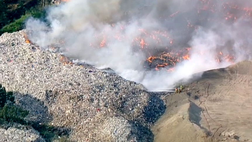 Aerial view of burning paper and smoke from a recycling plant fire.