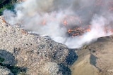 Aerial view of burning paper and smoke from a recycling plant fire.