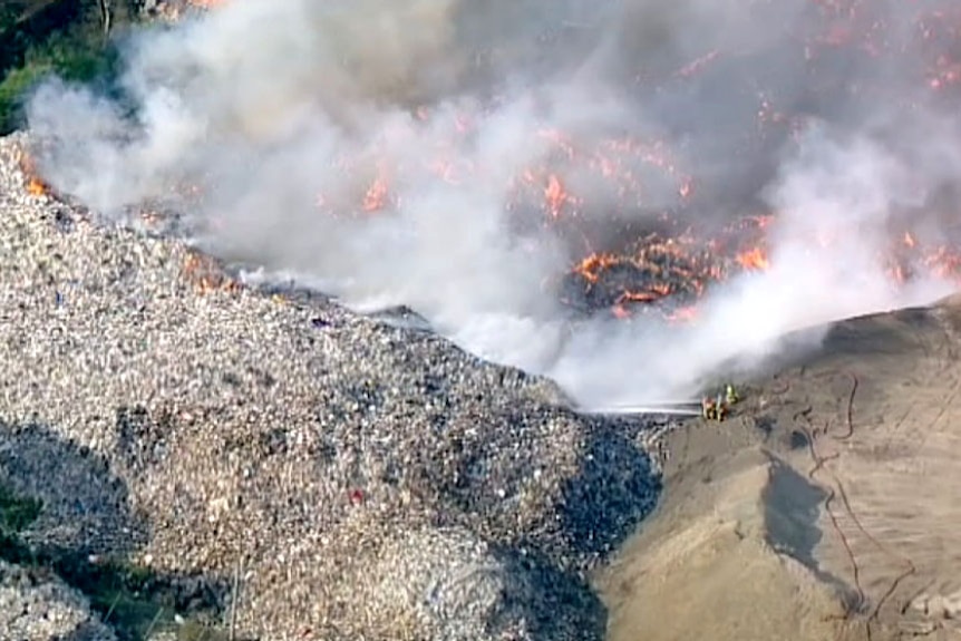 Aerial view of burning paper and smoke from a recycling plant fire.