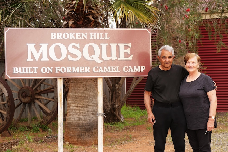 A couple standing at the sign of the Broken Hill Afghan Mosque