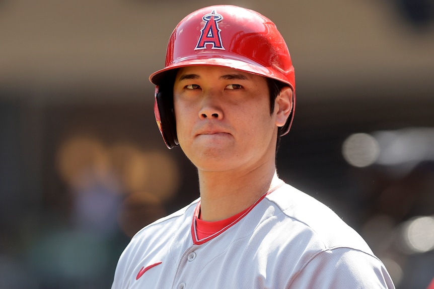 Shohei Ohtani looks to his left whiling wearing a batting helmet for the Los Angeles Angles in the MLB.