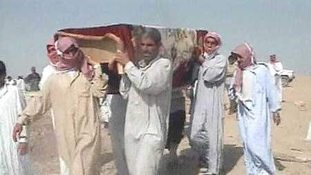 Iraqi men carry a body after an alleged US attack