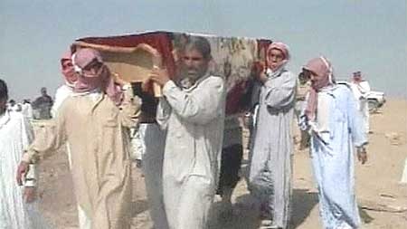 Iraqi men carry a body in the cemetery in Ramadi, following a purported US attack on an Iraqi wedding celebration.