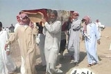 Iraqi men carry a body after an alleged US attack