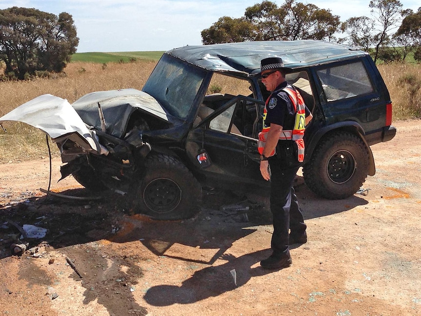 Police inspect one of the damaged vehicles