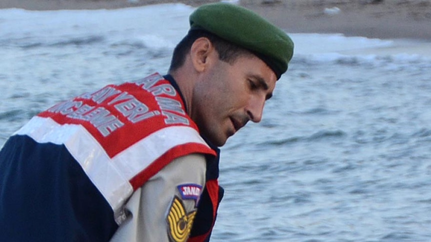 Cropped image of Turkish police officer carrying dead asylum seeker toddler