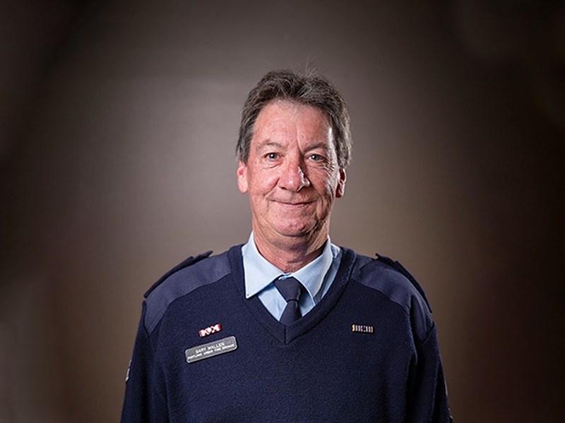 A firefighter in blue formal uniform looking at the camera.