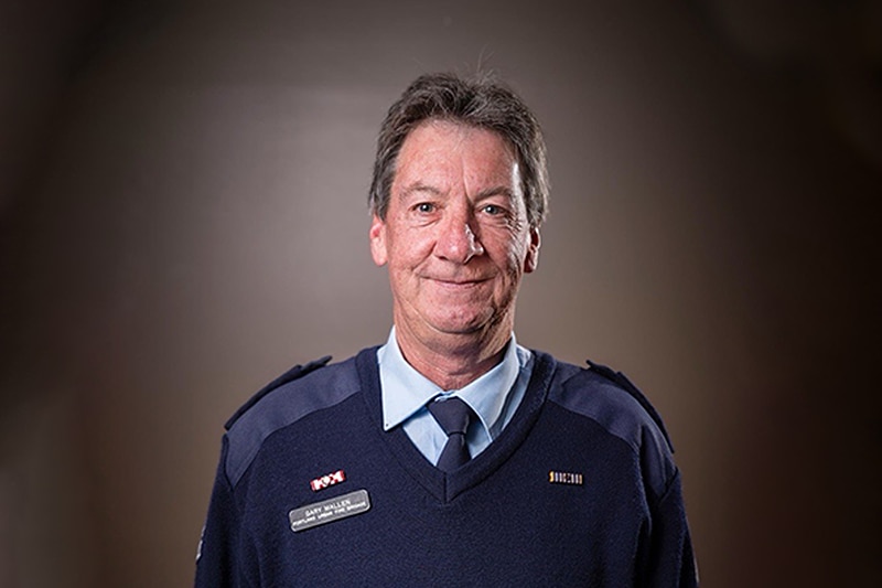 A firefighter in blue formal uniform looking at the camera.