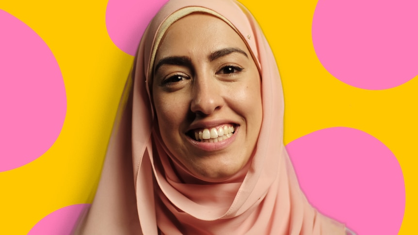 Aseel wears a pink headscarf and smiles at the camera.