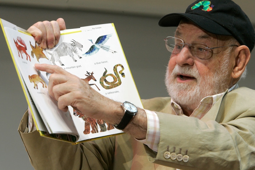 Author Eric Carle points to animals in one of his books as he reads aloud