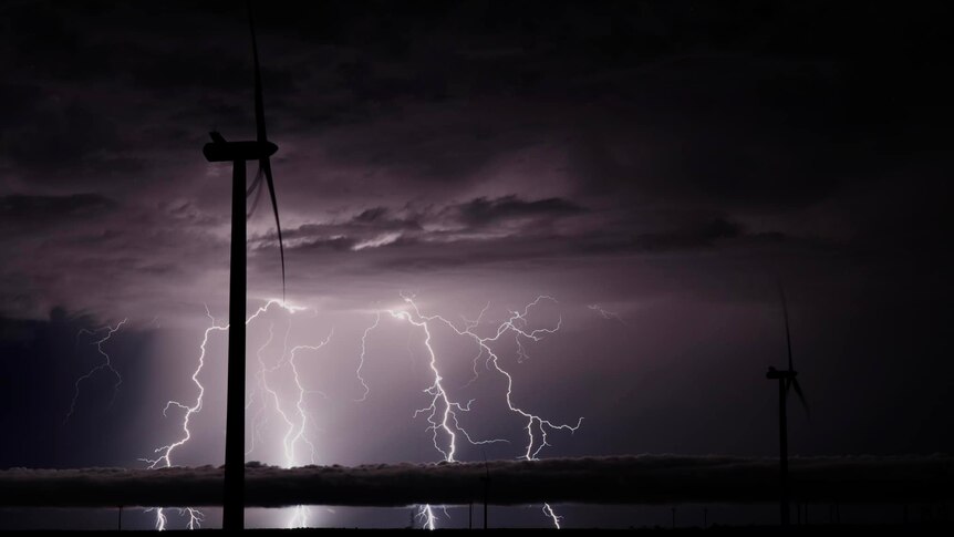 A storm with windmills in foreground