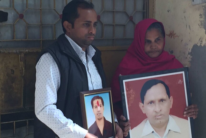 Akaash Chauhan and his mother hold up photos