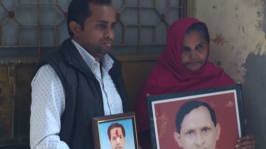 Akaash Chauhan and his mother hold up photos