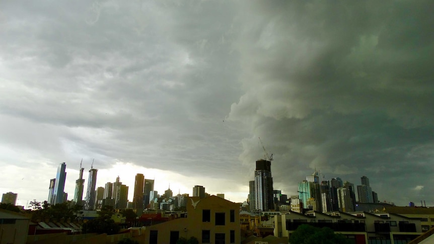 Grey, heavy storm clouds over the Melbourne city skyline.