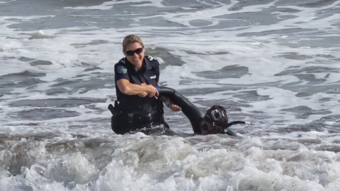 A passing police officer rescued a man from the sea