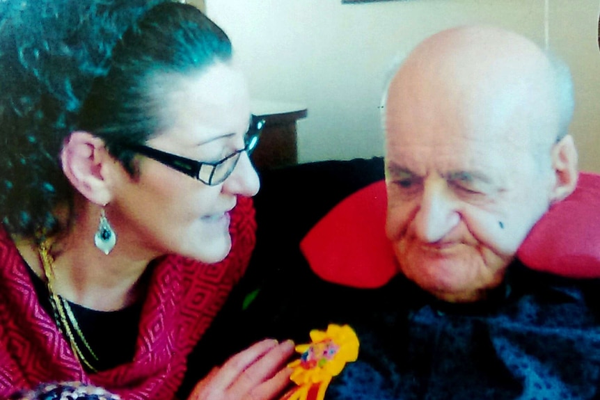 Noleen Hausler with her father Clarence Hausler sit together. He wears a cushion to prop his head up.