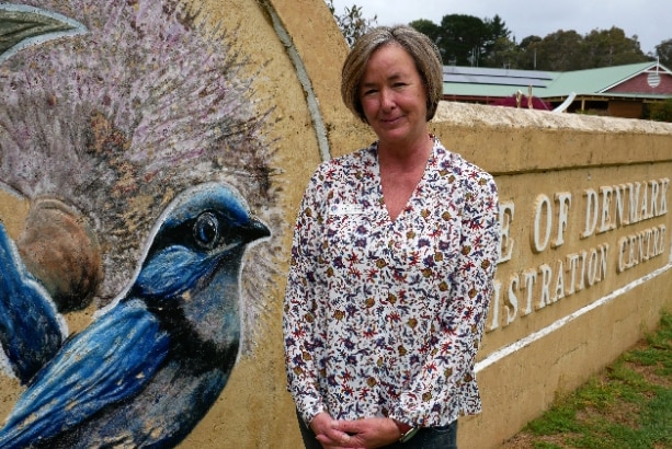 Denmark Shire President Ceinwen Gearon stands in front of the limestone wall featuring a blue bird.