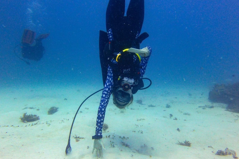 A lady in the ocean scuba diving