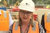Victorian Premier Jacinta Allan in a high vis jacket and hard hat addressing media.