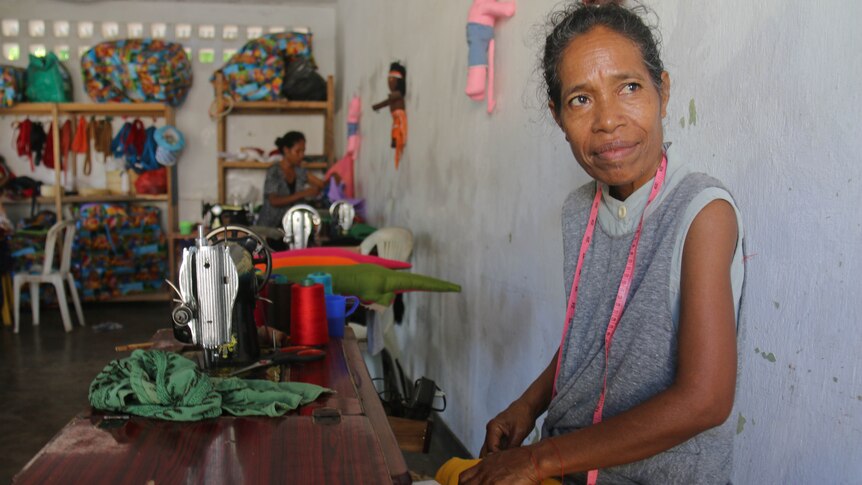 A Timorese women from a local cooperative holds a doll she is sewing.