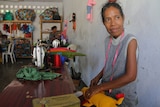 A Timorese women from a local co-operative holds a doll she is sewing.