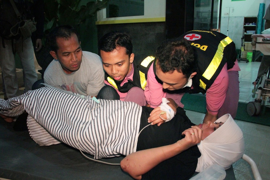 Medical staff transfer a female asylum seeker to a hospital in Lumajang, East Java.