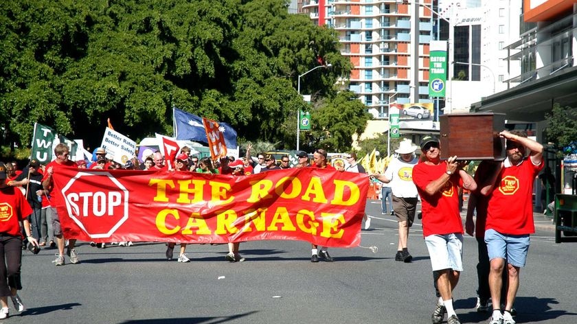 Members of the Transport Workers Union (TWU) carry a coffin during Brisbane's Labour Day march.