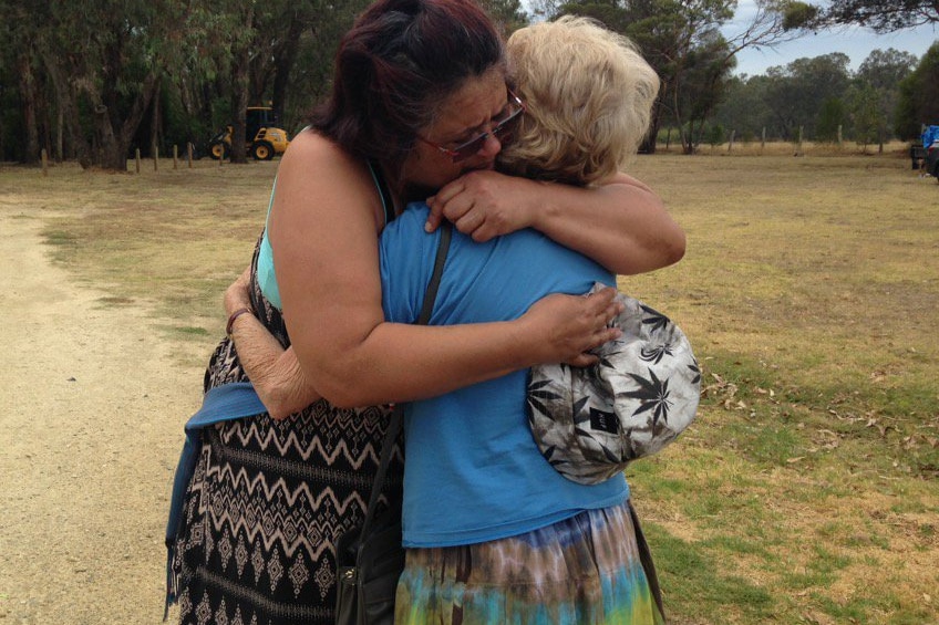 Yarloop residents Ada Farmer (left) and Kath King hug each other.