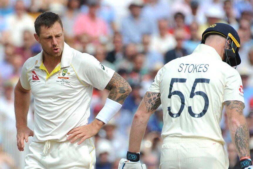 Australia bowler James Pattinson blows out as he walks past England batsman Ben Stokes.