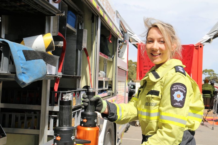 Female fire fighter Carly White standing beside a fire truck