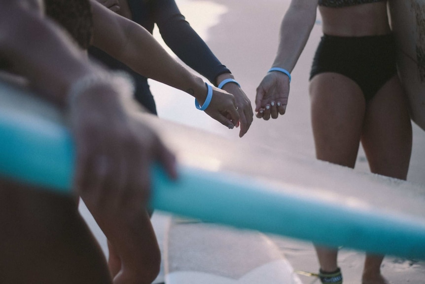 female surfers with blue wristbands