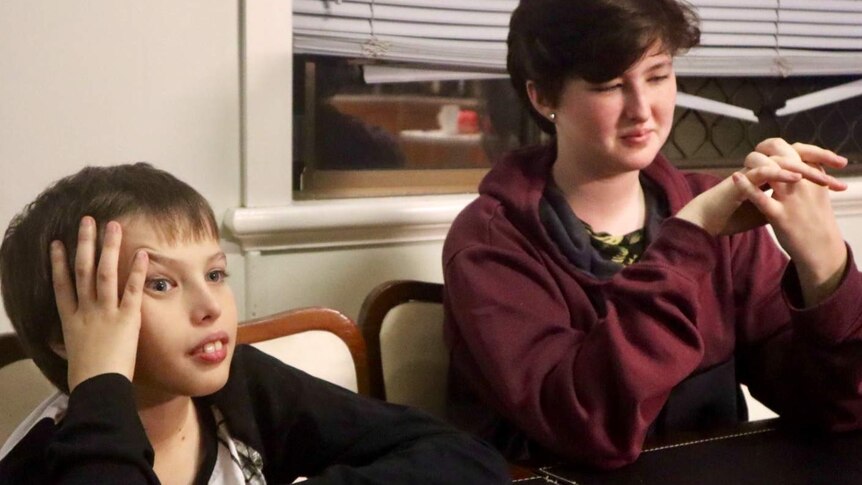 A boy and girl sit at a table.