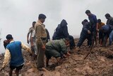 People pick through mud after India floods, landslides