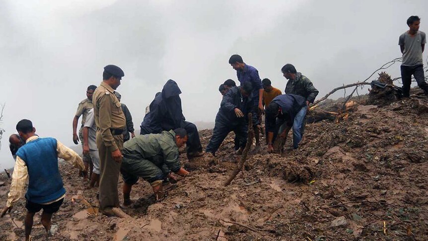 People pick through mud after India floods, landslides