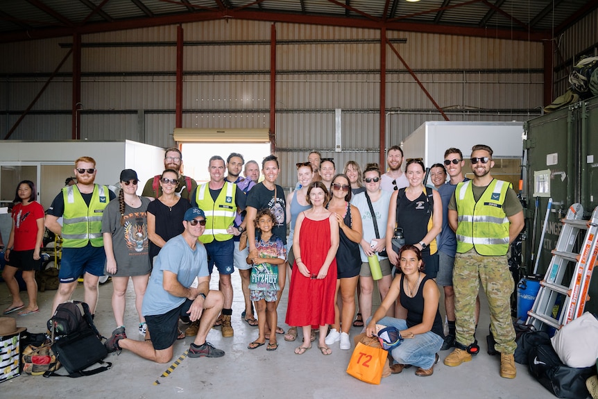 A group of people standing in a hangar.
