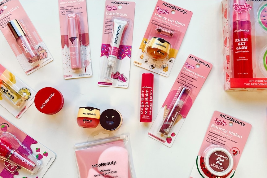 An overhead shot of pink cosmetics against a white background.