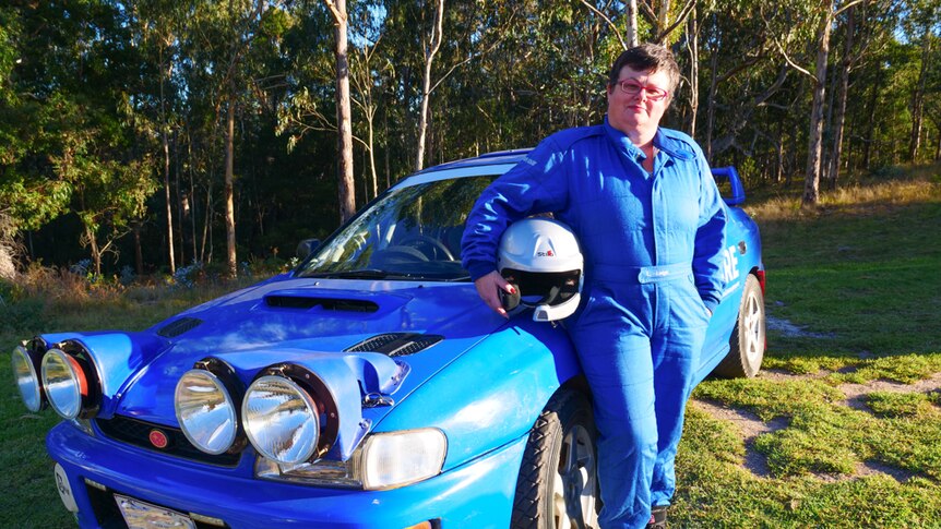 Portrait of female rally driver beside her car