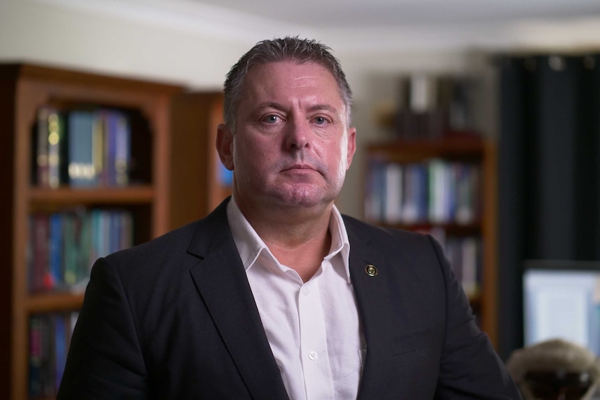 A portrait of a middle-aged man wearing a suit.