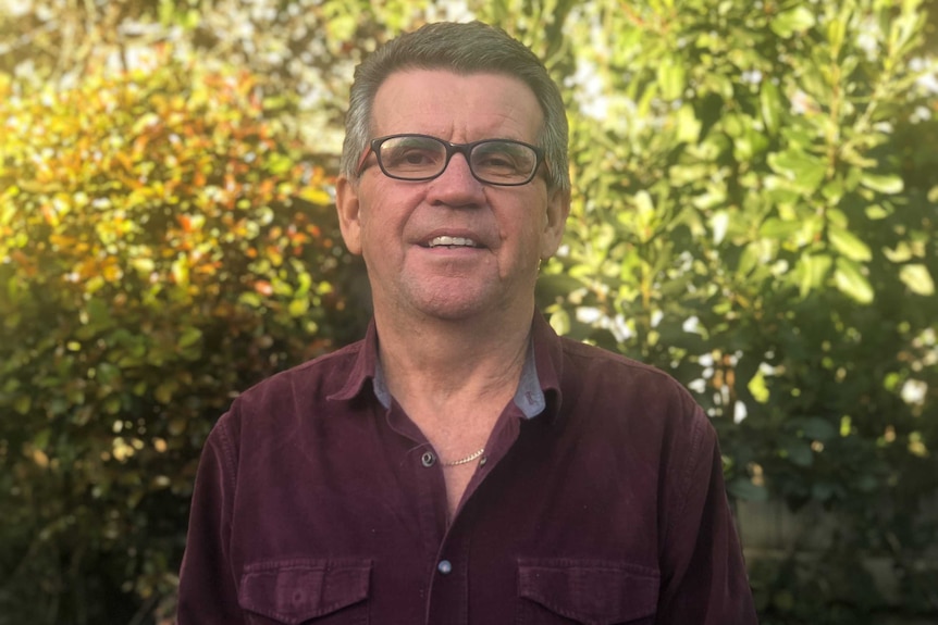 Max McGown stands outside in a garden.