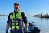 A man in maritime authority uniform at a marina