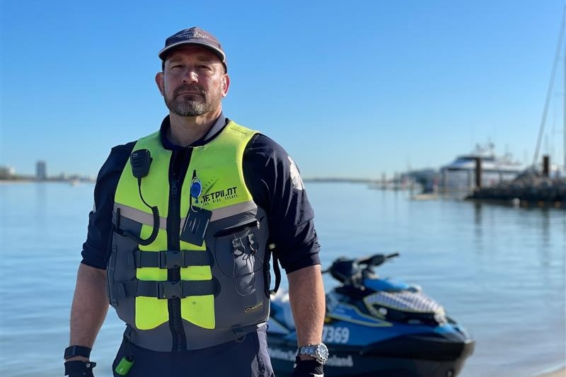 A man in maritime authority uniform at a marina