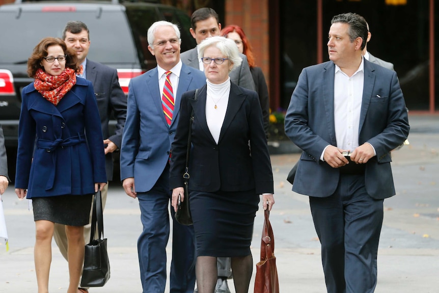 Rolling Stone contributing editor Sabrina Rubin Erdely, left, and Rolling Stone magazine Deputy Managing Editor Sean Woods, right, walk with their legal team to federal court in Charlottesville, Va., Tuesday, Nov. 1