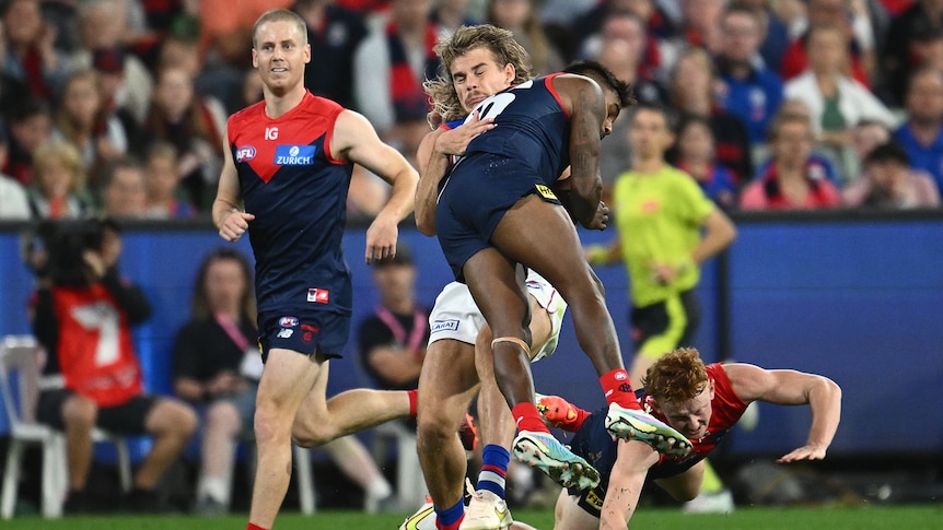 Kysaiah Pickett jumps as he hits Bailey Smith with a bump during an AFL game between Melbourne Demons and Western Bulldogs.